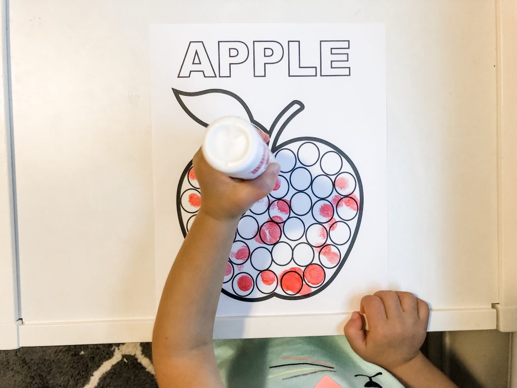 A fall apple activity with FREE PRINTABLES for your toddler to develop fine motor skills using stickers, crayons, or dot markers. Help them to learn colors & counting as well during this activity.