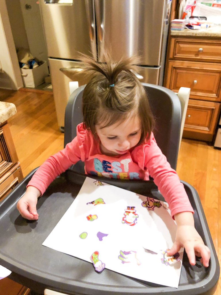 Christmas activity using stickers for your toddler that incorporates language, fine motor skills, and hand eye coordination.